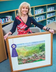 Charlotte holding a framed artwork with an award ribbon
